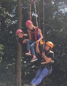A PALS member climbing with two carers