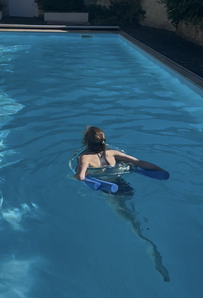 Ottilie swimming with pool noodle